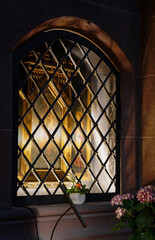 Fototapeta na wymiar Marienbildnis hinter Gitter an einem Kirchenfenster