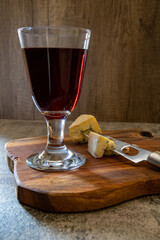 Red wine with blue cheese isolated on the wooden board in a rustic glass
