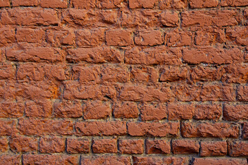 Old weather-beaten grunge red brick wall background 