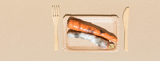 Banner made of carrots wrapped in polyethylene plastic on the beige paper background. Immature,...