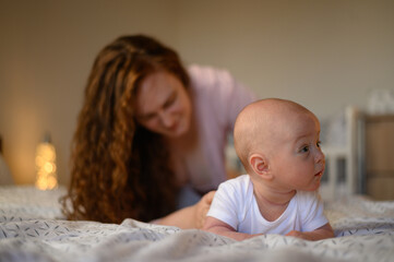 Baby playing while lying on a bed during his tummy