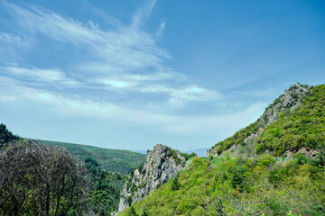 Fototapeta premium magnificent and huge stones standing near the road in old road to Bursa to Nicaea (iznik) during sunny day and big electricity transmission tower and multiple cables behind the sky.