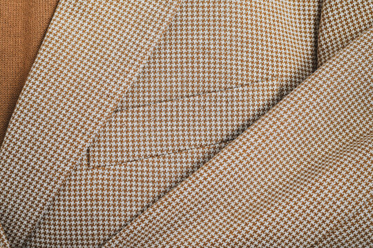 Detail of men outwear, light beige blazer with a pocket and sleeve patch fragment. Top view.