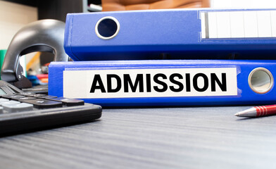 Office desk and notebook with text - ADMISSION PROCESS on the office table among the stationery.