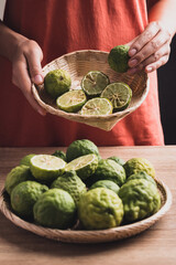 Fresh bergamot fruit in a basket holding by woman hand, Food ingredients and extract used for medicine, tea, perfumes and cosmetics