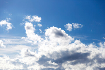 light white fluffy clouds float across the blue sky. Texture of clouds and sky