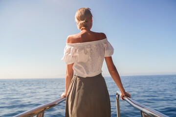 Fototapeta na wymiar Joyful woman on sailing boat discovering ocean life on summer cruise.
