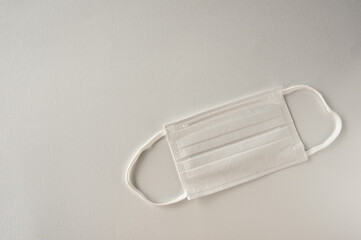 A non-woven disposable mask is on a white background. This is a symbol of the coronavirus infection control.