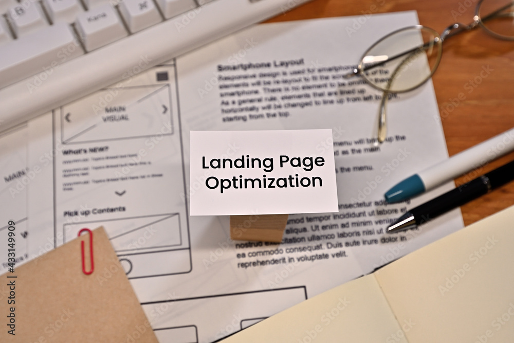 Poster on a desk with a keyboard and a piece of paper with a dummy web design on it, there is a card with t