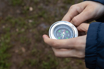Selective focus of a detail of a girl's hands holding a compass