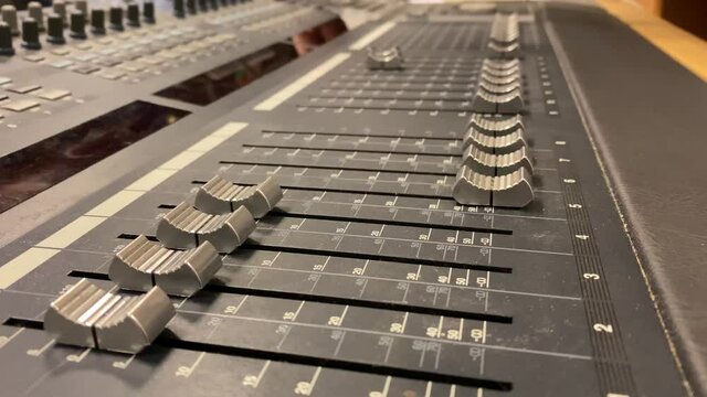 Sound engineer console and faders moving along it during operation
