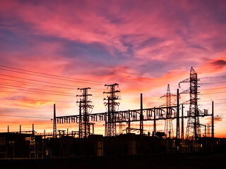 Power transformer substation, electricity transformer substation, electric transformation center, silhouette against a sky at sunset, horizontal