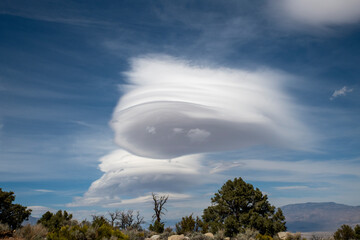 Skyline view of lenticular cloud, mountains, rocks. Alabama Hills, California
