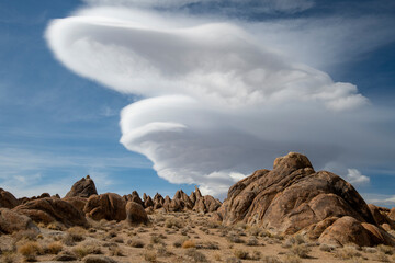 Skyline view of lenticular cloud, mountains, rocks. Alabama Hills, California
