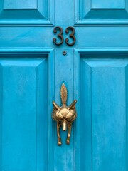 House number 33 on a blue wooden front door with a fox as door knocker