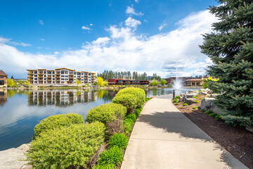 Riverstone public park in Coeur d'Alene, Idaho, USA, with restaurants, new construction and the water fountain spraying in the small lake.