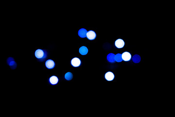 glowing blue and white bokeh balls in dark background