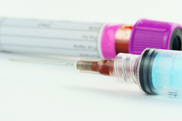 Vacuum tube for collection and blood samples on white background..Transparent with purple cap and a...