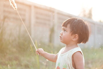 child blowing dandelion