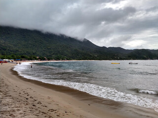 beach with pareia and rocks with cloudy sky