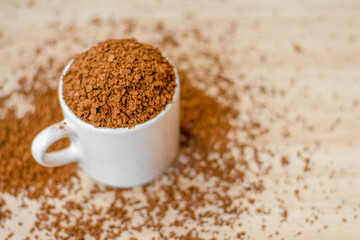 instant soluble coffee In a white ceramic mug on Wooden floor, top view.