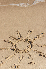 Shape of sun with incoming sea wave on sand at beach. Summer and vacation time