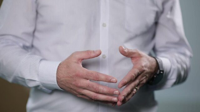 Details with the hands of a man gesticulating during an interview.