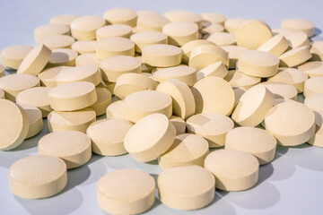 Herbal pills with healthy medical plant on gray background. Close up of compressed pills from herb powder, alternative medicine.