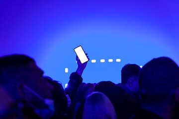Mockup empty white smartphone screen, people in night club party concert