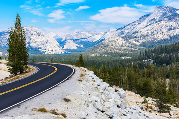 Scenic Tioga Pass road running through Sierra Nevada mountain scenery on sunny day in summer near Olmsted Point in Yosemite National Park
