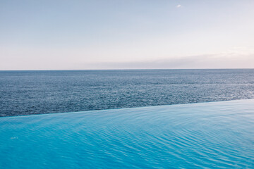 Infinity pool, sea and blue sky on background. Just relax and chill. Nobody. Clear horizon. 