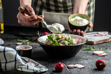 cooking vegetarian salad of fresh organic radish and green onions dressed with sour cream