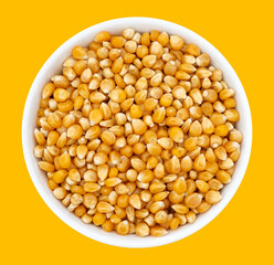 Top view of bowl with Popcorn Kernels Uncooked. Popcorn Kernels Uncooked in a Ceramic Bowl. The image is a cut out, isolated on a white background, with a clipping path