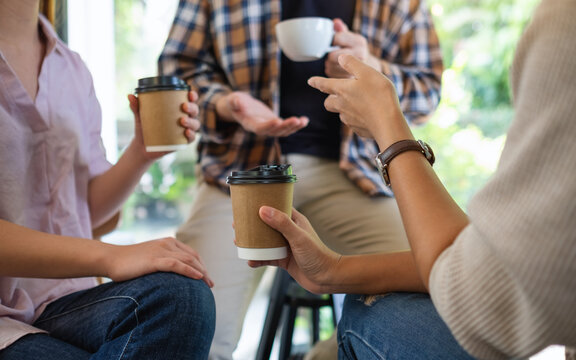 Closeup image of a group of young people enjoyed talking and drinking coffee together