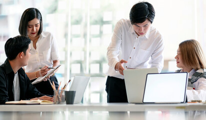 Group of business people working and discussing together in modern office.