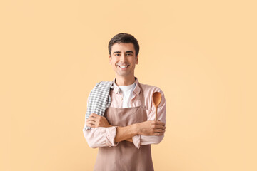 Young man with napkin and spoon on color background