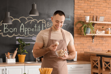 Young man with mushrooms in kitchen