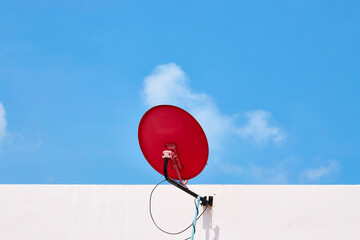 red satellite dish on brick wall