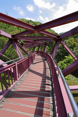 Fototapeta na wymiar 山奥にある湾曲した赤い鉄橋の風景