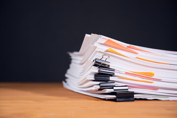 Paper documents stacked on wooden desk