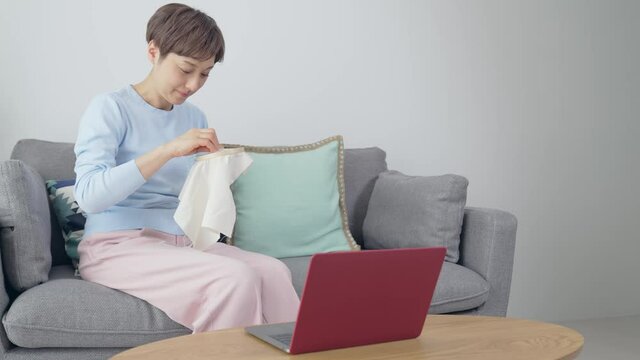 パソコンを見ながら刺繍をするミドル女性　オンライン手芸教室