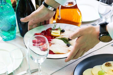 the waiter is holding a plate with salt fish slices