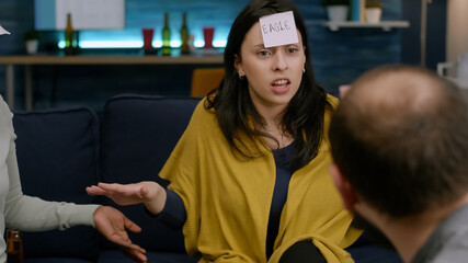 Funny multi-ethnic friends with sticky notes on forehead enjoying guess who game. Group of...