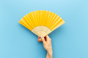 Hand fan made of bamboo and paper in female hand - obrazy, fototapety, plakaty