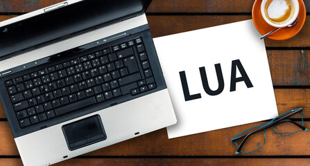 Lua Programming Language.  Word Lua on paper and laptop
