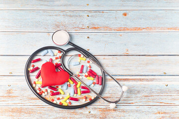 Fototapeta na wymiar Stethoscope, pills and red heart. Heart check. World heart day