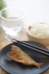 Fried dry fish on black plate eating with cooked rice, Asian cuisine