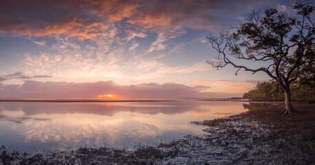 Obraz na płótnie Canvas Panoramic Seaside Sunrise with Dramatic Sky and Reflections