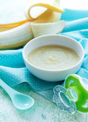 Bowl with fruit baby food and banana