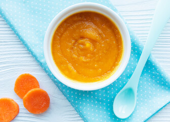Baby carrot mashed with spoon in bowl